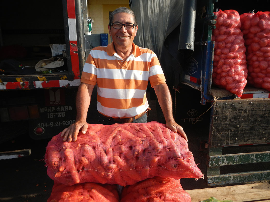 Fotografía de un agricultor con un saco de zanahorias